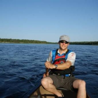 a man sitting in a boat on a body of water