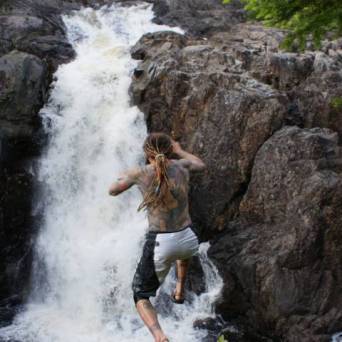 a man standing next to a waterfall