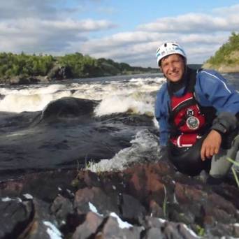 a man standing next to a body of water
