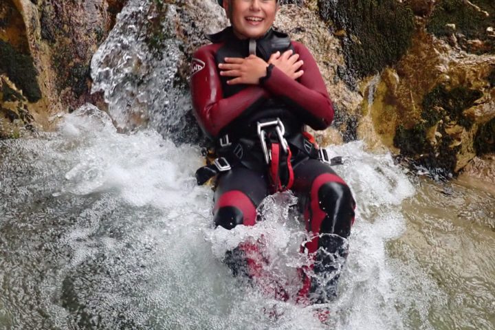 a young boy riding a snow board in the water
