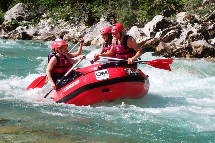 a group of people riding on the back of a boat in the water